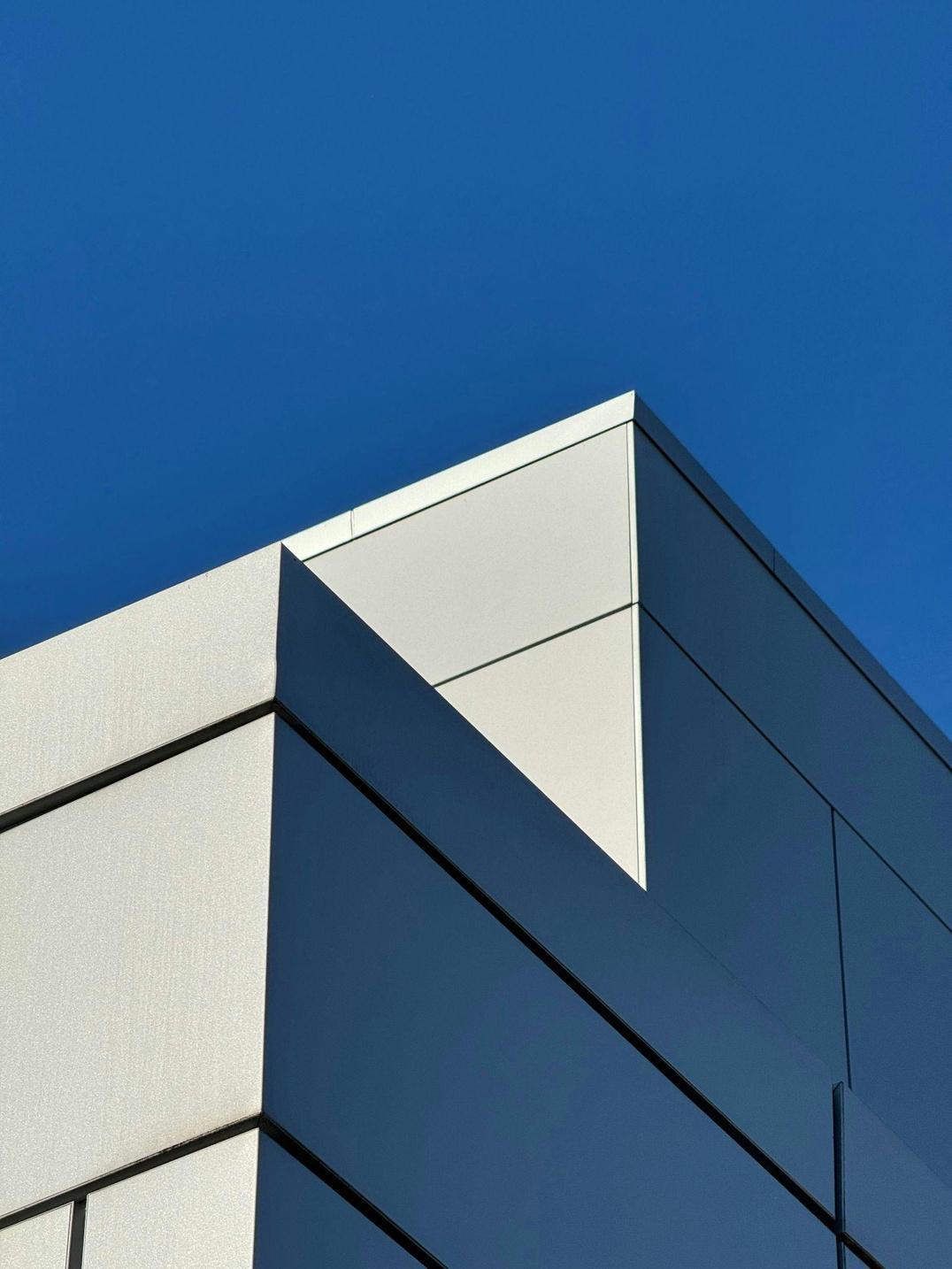 Dramatic low-angle of a concrete building corner against deep blue sky